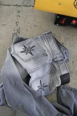 Pantalón de jean recto de tiro medio color gris oscuro con costuras verticales.