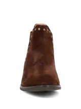 Botines de gamuza color marrón oscuro con diseño tipo chelsea, detalle de tachas metálicas a lo largo del elástico lateral y suela de goma con tacón bajo.