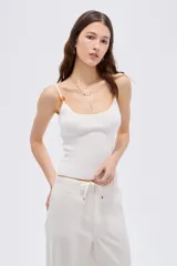 Musculosa de viscosa al cuerpo con cuello redondo y breteles finos decorados con cuentas.