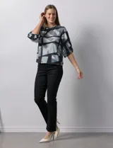 Blusa de gasa con estampado geométrico en tonos negro, gris y celeste. Tiene cuello redondo y mangas 3/4 amplias con abertura y botón.