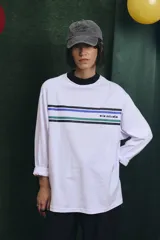 Remera de manga larga blanca con cuello alto en color azul. Presenta franjas horizontales de colores en el pecho y el logo de la marca estampado.