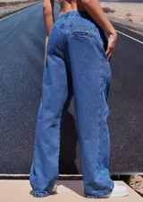 Pantalón de jean azul de corte babucha, tiro medio, con elástico en la cintura, bolsillos delanteros y logo bordado en amarillo en la pierna derecha.