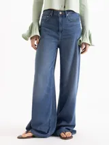 Jeans wide leg de tiro medio en tono azul medio con acabado lavado. Confeccionados en un blend de lyocell, rayón y poliéster.