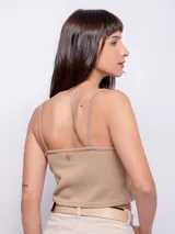 Top color beige al cuerpo sin mangas, con escote en v, tirantes finos y abertura en parte central.