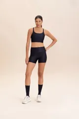 Top deportivo de compresión media con diseño de espalda cruzada y breteles finos. Confeccionado en tejido acanalado con un acabado de brillo sutil, cuenta con copas removibles y tecnología de ajuste adaptable.