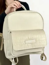 Mochila de cuero color crema con bolsillo frontal con textura de piel de cocodrilo.