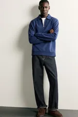 Sudadera polo de corte regular, confeccionada en tejido técnico interlock de algodón con elasticidad. Presenta cuello solapa, cierre frontal de cremallera y manga larga con puños acabados en rib.