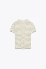 Top tipo chaqueta de punto a rayas horizontales color beige y blanco, con escote en pico, manga corta, volantes en el escote y cierre frontal con botones.