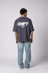 Remera oversize negra de manga corta, con cuello redondo y pequeño estampado frontal con las letras "CNPT".