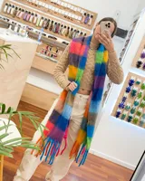 Bufanda larga tejida a crochet con diseño de cuadros grandes en colores vibrantes y flecos en los extremos.