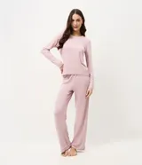 Pijama de dos piezas compuesto por una blusa de manga larga con cuello redondo y bolsillo frontal, y un pantalón recto con cintura elástica. Ambas prendas presentan detalles de piping en los bordes. Confeccionado en tejido de viscolycra suave y fluido.