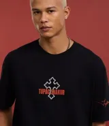 Remera negra de algodón con corte relajado, cuello redondo y mangas cortas. Estampa frontal y trasera con la imagen de Tupac Shakur y texto con tipografía gótica.
