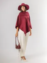 Poncho de tejido texturizado en color marrón chocolate, con cuello amplio y diseño asimétrico.