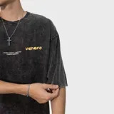 Remera de algodón con efecto acid wash gris oscuro, de corte oversize, cuello redondo, mangas cortas y estampa frontal en tono amarillo.