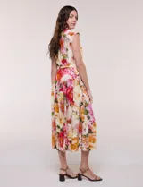 Vestido midi de calce fluido y corte camisero, con estampado floral en tonos rosa, rojo, amarillo y verde. Cuenta con cuello camisero, escote en V, abotonadura frontal oculta, mangas cortas tipo cap sleeve, lazo ajustable en la cintura del mismo género y falda evasé con recorte fruncido.