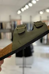 Sandalia marrón con diseño de dos tiras ajustables con hebillas metálicas y plantilla anatómica.