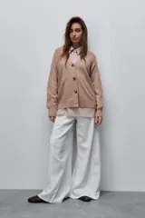 Cardigan de punto color beige, con escote en V, cierre frontal con botones oscuros y mangas largas con detalles de tejido en relieve.