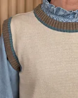 Chaleco tejido de punto color verde con detalles en tostado en el cuello redondo, sisas y dobladillo inferior.