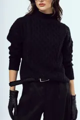 Sweater tejido negro de silueta relajada, con cuello alto y textura trenzada.