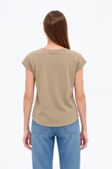 Remera de algodón color verde militar, con mangas cortas con dobladillo y estampado frontal abstracto con detalles en foil dorado y negro.