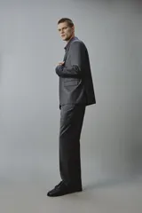 Blazer gris oscuro de corte regular fit con diseño de raya diplomática, confeccionado con mezcla de lana. Presenta solapas de muesca, cierre frontal de dos botones, bolsillos con solapa en la cadera y un bolsillo de vivo en el pecho.