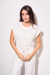 Remera blanca de algodón con textura de puntos calados horizontales, corte al cuerpo y mangas cortas tipo mariposa.