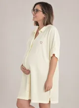 Camisón maternal color amarillo claro, confeccionado en viscosa suave y liviana. Presenta cuello camisero, cierre frontal con botones y un sutil bordado de corazón rojo en el pecho.