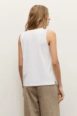 Musculosa cruda de corte recto y sin mangas, con cuello redondo y diseño estampado en relieve en el borde inferior.