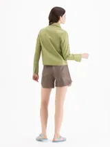 Chaqueta de cuero ovino color verde, de calce levemente entallado, cuello camisero clásico, mangas largas con puño, cierre frontal con broches a presión ocultos y dos bolsillos en la zona del busto.