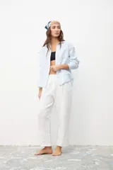 Camisa de lino en color celeste, con cuello clásico, cierre frontal de botones y bolsillo en el pecho.