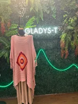 Poncho tejido artesanalmente en lana y acrílico color rojo, con aplique de crochet multicolor y terminación en flecos.