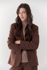 Blazer negro de poliéster, viscosa y spandex, con forro animal print, hombreras, botones frontales y en mangas.