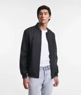 Campera bomber negra para hombre, confeccionada en material gomoso, con cuello alto, puños y bajo acanalados, y cierre frontal con cremallera.