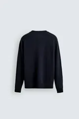 Cárdigan de punto en color verde oscuro, con cuello en pico, manga larga y cierre frontal con botones. Presenta acabados en rib en puños y bajo.