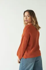 Sweater tejido de punto color ladrillo, con escote en V y mangas largas.