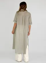 Camisa larga color borgoña, de corte recto, con cuello camisero, mangas cortas con puños arremangados y cierre frontal con botones.