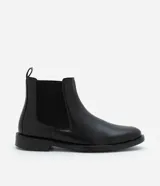 Bota tipo Chelsea de caña media, color negro, con paneles laterales elásticos y suela de goma. Diseño de punta redonda y estilo minimalista.