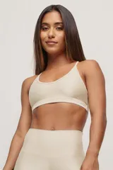 Top deportivo color beige, de breteles finos y espalda deportiva.