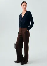 Cardigan de punto fino con cuello en pico y cierre frontal con botones. Presenta un diseño recto y mangas largas.