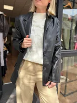 Sweater de punto color blanco con cuello alto y diseño de textura en relieve. Presenta mangas largas con puños acanalados y un corte holgado.