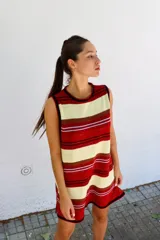 Vestido corto sin mangas, de tejido de punto en color azul marino con efecto jaspeado o tweed en tonos claros. Presenta un corte amplio y relajado, con cuello redondo y bordes en contraste.