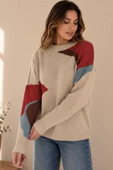Buzo de punto color beige con diseño geométrico y abstracto en tonos rojo, azul y marrón, de corte holgado, cuello redondo y mangas largas.