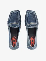 Mocasines de mujer Diesel D-Amber con taco bajo y fino, confeccionados en denim azul. Presentan puntera cuadrada, detalles fruncidos en el empeine y tira frontal con aplique metálico del logo de la marca.