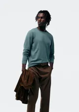 Buzo de punto para hombre en color gris oscuro, con cuello redondo, manga larga y terminaciones acanaladas en puños y cintura.