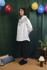Camisa de corte oversize con mangas largas y puños abotonados. Presenta un diseño bicolor con cuerpo blanco y un canesú delantero con estampado floral multicolor.