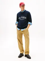 Buzo de algodón orgánico color azul marino con cuello redondo y terminaciones acanaladas. Presenta un gran logo gráfico de Tommy Hilfiger con el texto "Heritage & Excellence" y la inscripción romana "MCMLXXXV" en blanco en el frente.