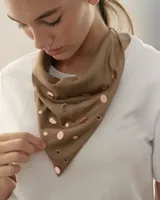 Bandana triangular de símil gamuza color marrón, decorada con apliques de acrílico espejado en formas circulares y de estrellas.