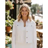 Campera de jean color negro con apliques de perlas en la parte superior frontal. Presenta cuello clásico, cierre frontal con botones metálicos y dos bolsillos en el pecho.