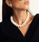 Collar de cuentas redondas y aplanadas con efecto marmolado en tonos grisáceos, con cierre metálico dorado.