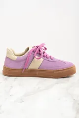 Zapatilla urbana de gamuza color lila con detalles en beige y suela marrón.